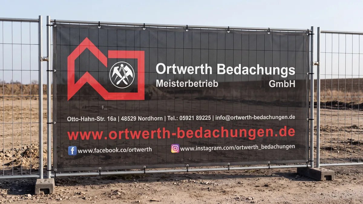 Bauzaunplane eines Nordhorner Dachdeckerbetriebs an einem Bauzaun