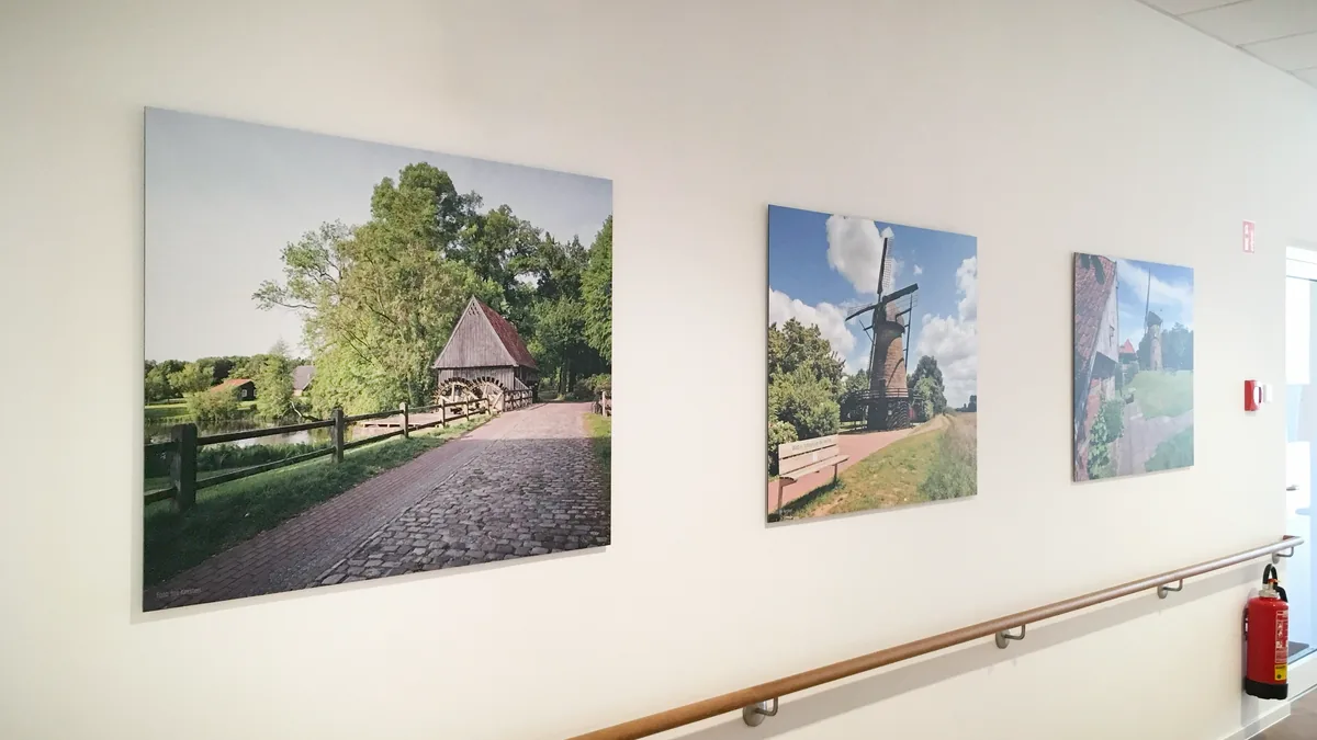 Flur einer Einrichtung mit drei großformatigen Landschaftsbildern an der Wand