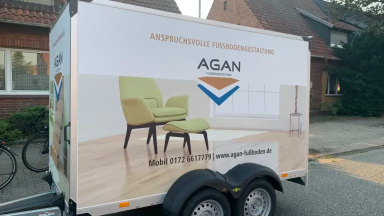 Weißer Kofferanhänger mit großflächigem Raumbild und Logo auf der Seitenwand