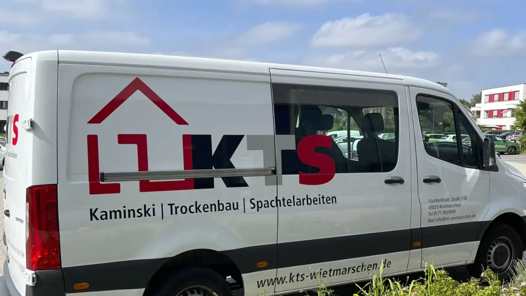 Weißer Kastenwagen mit großem Logo und Leistungsangaben auf der Seitenwand