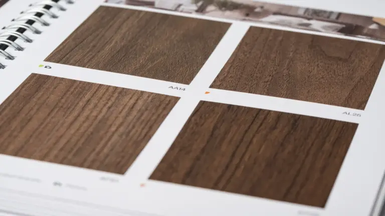 Aufgeschlagener Musterkatalog mit dunklen Nussbaum-Holzdekoren
