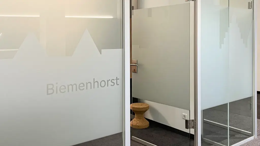 Folierte Glastür mit Ortsname und Silhouette als Sichtschutz